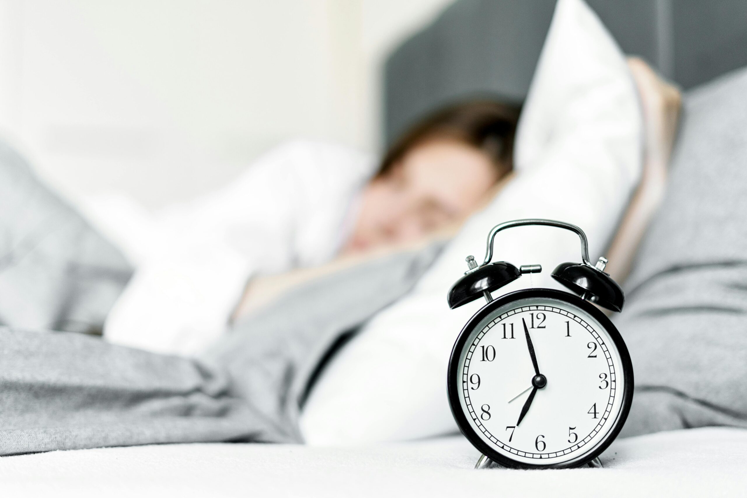 Woman sleeping in bed during Better Sleep Month